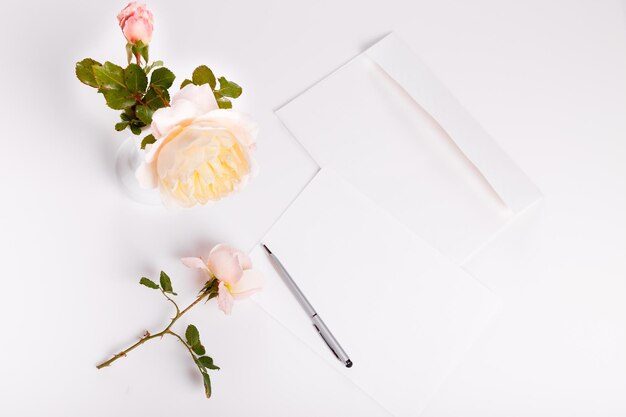 Stylo lettre et enveloppe blanche sur fond blanc avec rose anglaise rose Cartes d'invitation ou lettre d'amour Concept de jour de mariage de la Saint-Valentin de la mère de la femme