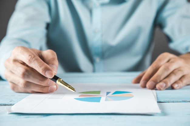 Stylo à main de l'homme et papier millimétré sur la table