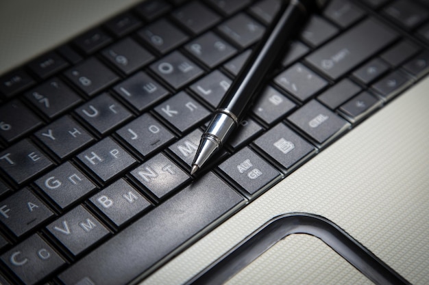 Stylo noir sur le clavier de l'ordinateur