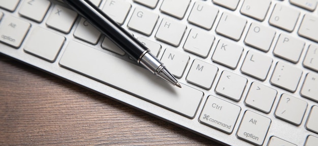 Stylo noir sur le clavier de l'ordinateur