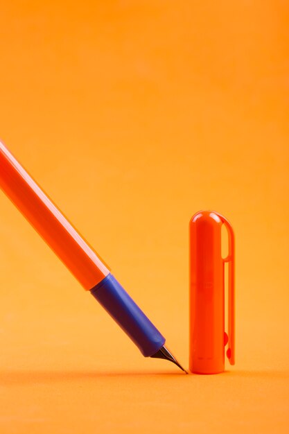Stylo plume avec un capuchon sur fond orange
