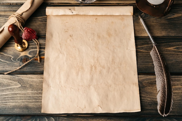 Un stylo à plume et une vieille feuille de papier sur fond de bois