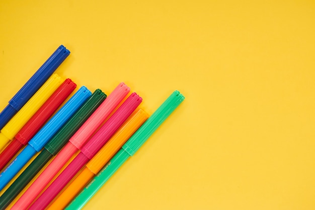 Stylos colorés sur fond jaune