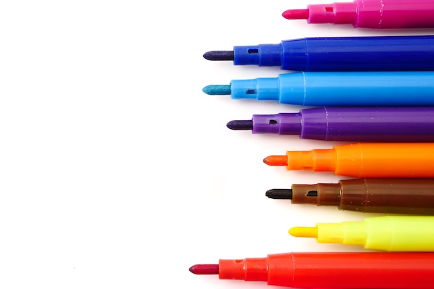 Stylos colorés magiques sur un fond blanc. Espace libre pour le texte