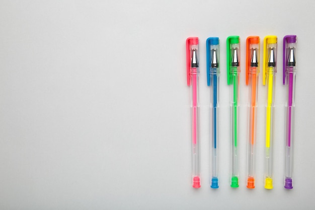 Stylos de différentes couleurs sur une surface grise avec espace de copie