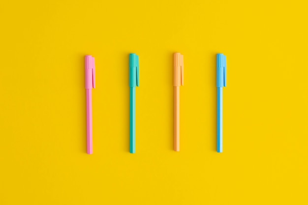 Stylos multicolores sur fond jaune