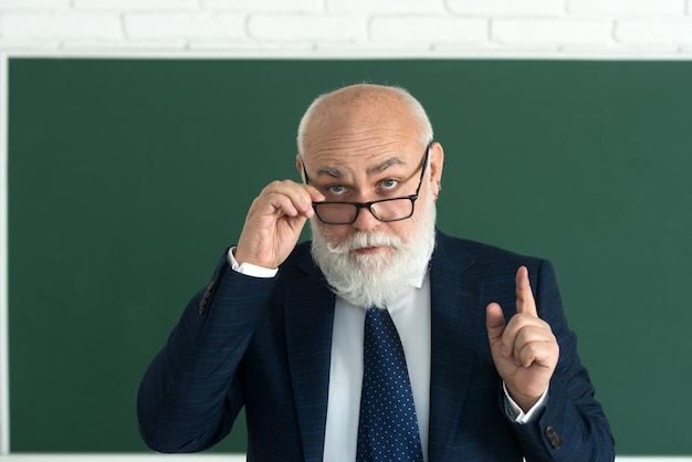 Succès académique mature professeur élégant avec des lunettes professeur de pensée scolaire ou collège et univer