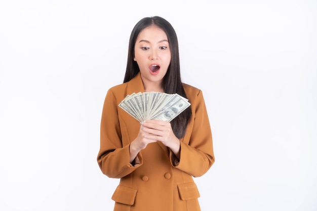 Succès belle entreprise asiatique jeune femme tenant de l'argent des billets en dollars américains à la main isolé sur fond blanc avec copie espace concept d'entreprise