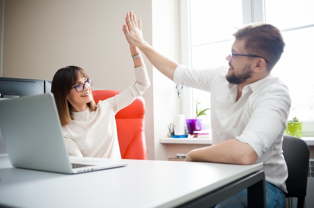 Succès des jeunes employés au bureau. Donnez-vous cinq