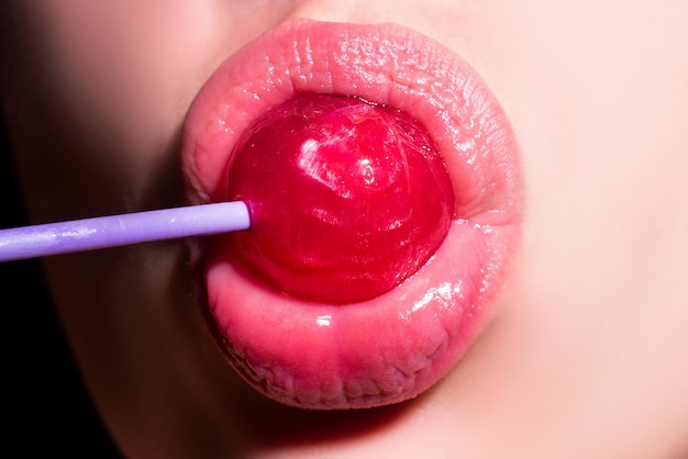 Sucer les lèvres lécher la bouche sucette lèvres brillantes femelles rouges et sucette rose bonbon