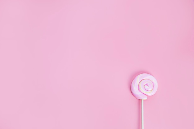 Sucette spirale colorée sur fond rose vue de dessus bonbons durs sucre bonbons concept espace copie
