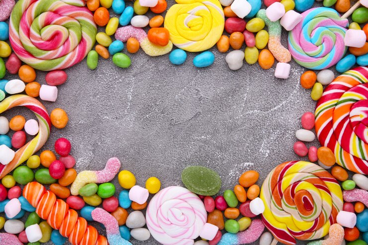 Sucettes colorées et bonbons ronds de différentes couleurs sur fond de béton