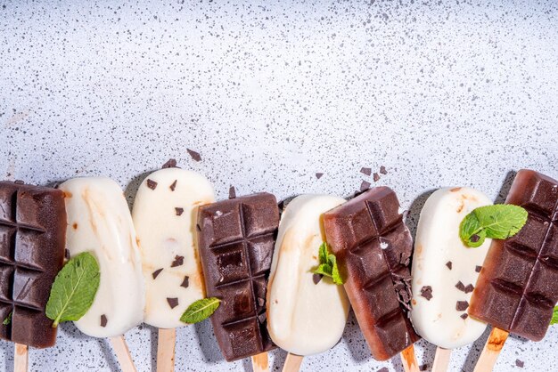 Sucettes glacées au chocolat et à la vanille Sucettes glacées classiques au cacao et à la crème de lait brun foncé Pile de diverses sucettes glacées flatlay vue de dessus espace de copie