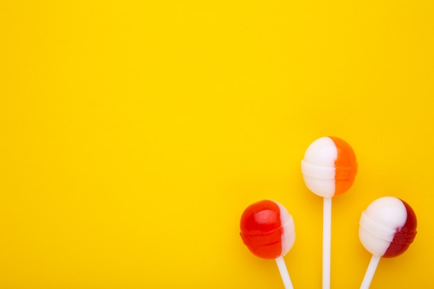 Sucettes sucrées sur fond jaune. concept de bonbons sucrés