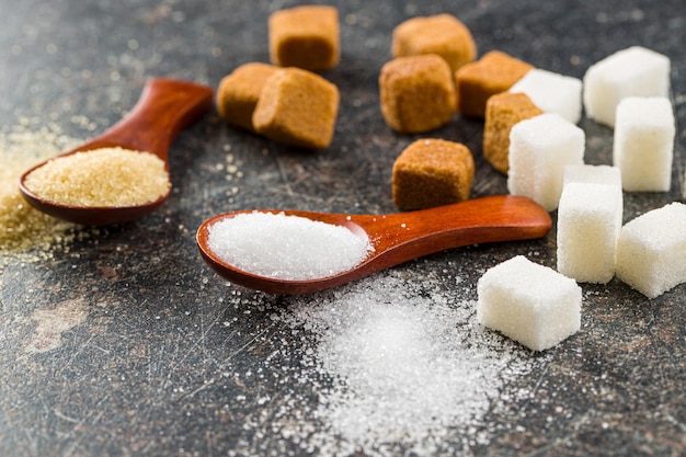 Photo sucre blanc et brun dans des cuillères en bois