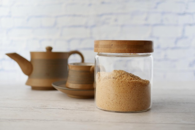 Sucre de coco en pot et une tasse de thé sur la table