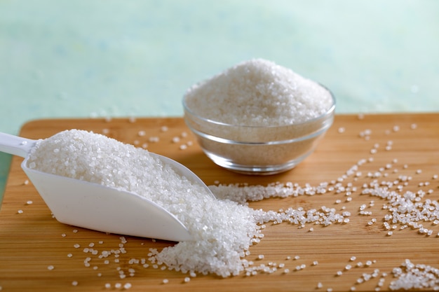 Sucre dans un bol en verre sur fond en bois