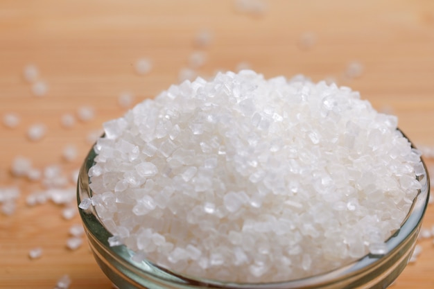 sucre dans un bol en verre sur fond de bois