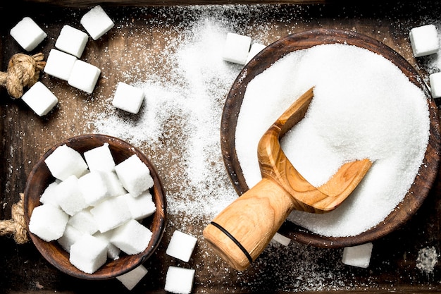 Sucre dans un vieux plateau en bois avec cuillère en bois