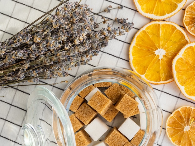 Sucre instantané grumeleux, bouquet de lavande et tranches de citron séché sur une nappe à carreaux