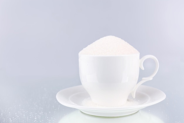 Sucre en tasse sur fond gris