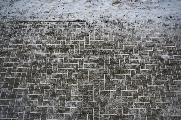 suit la neige asphaltée, la glace, les traces des gens des chaussures sur la neige, le temps de déneigement