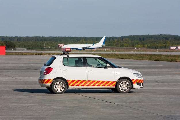 Suivez-moi la voiture attend l'avion sur le tablier de l'aéroport