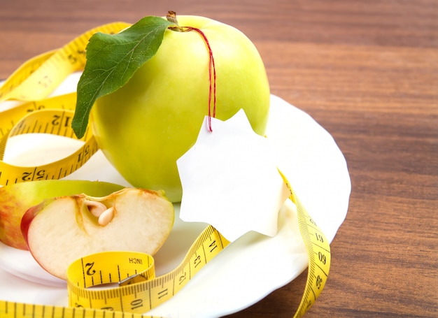 Suivre un régime et des aliments sains. Pomme jaune, verte avec feuille, ruban adhésif et autocollant