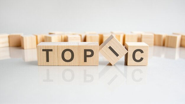 Sujet - mot de blocs de bois avec des lettres sur fond gris. Reflet de la légende sur la surface réfléchissante de la table. Mise au point sélective.