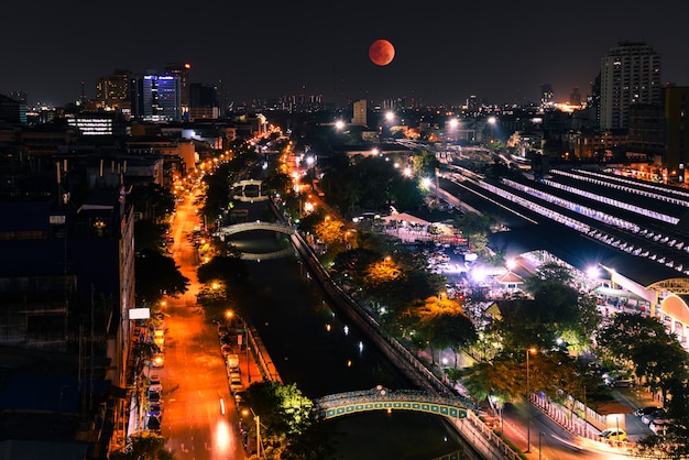 Super Blood Moon dans le ciel. Avec vue grand angle de Bangkok la nuit.