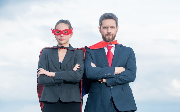 Super couple d'affaires en costume de super-héros sur fond de ciel