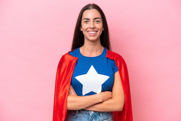 Super Hero Caucasian woman isolé sur fond rose en gardant les bras croisés en position frontale