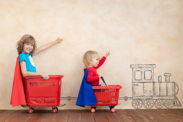 Super-héros d'enfants heureux jouant à la maison.