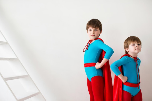 Photo super-héros de garçons dans un manteau rouge dans le vent et le masque concept de victoire et de succès