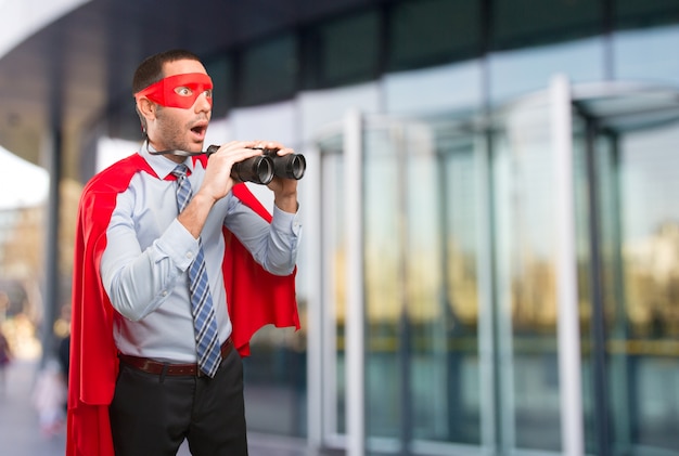 Super homme d&#39;affaires surpris en utilisant une jumelle