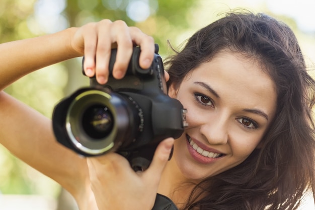Photo superbe femme brune tenant son appareil photo