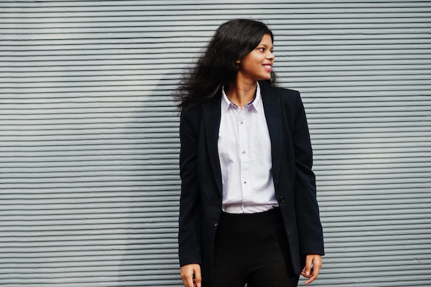 Photo superbe femme indienne porter une pose formelle contre un mur gris