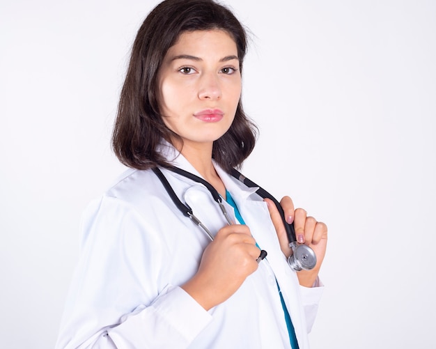 Superbe femme médecin à l'aide d'un stéthoscope sur espace blanc