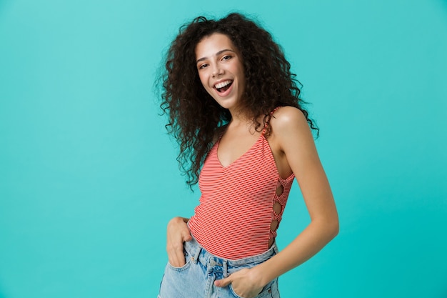 Superbe femme portant des vêtements décontractés souriant, debout isolé sur mur bleu