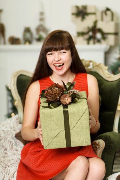 Superbe fille posant dans des décorations de Noël festives. Excité pour les vacances d'hiver.