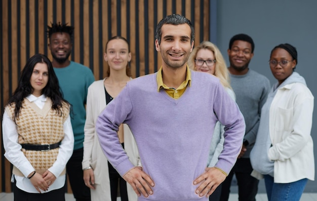 Superbe homme décontracté en chemise violette debout avec les mains sur la hanche avec impatience joyeusement