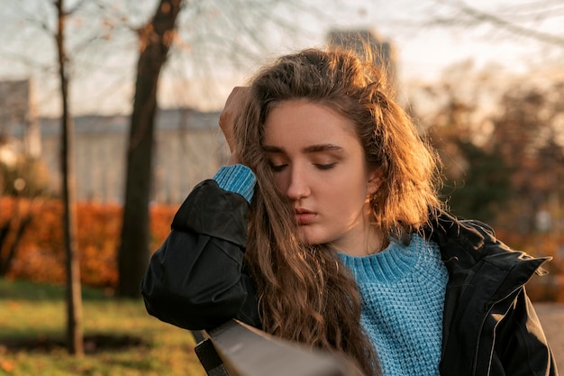 Superbe jeune femme aux longs cheveux auburn ondulés Portrait attrayant beau modèle aux cheveux bruns ondulés dans le parc en automne