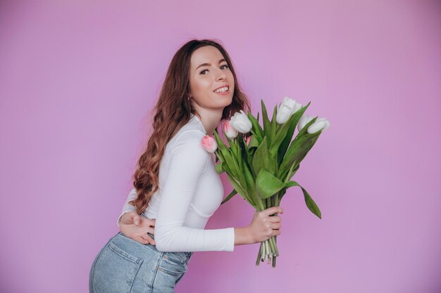 Superbe jeune femme ravie de recevoir un bouquet de tulipes pour la journée de la femme