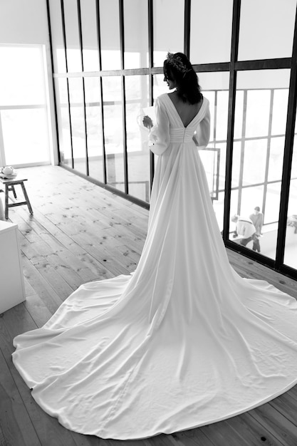 Superbe mariée vêtue d'une robe de mariée blanche avec une longue traine photo en noir et blanc