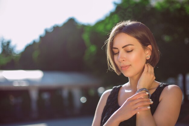 Superbe modèle brune avec bronzage bronze et maquillage naturel marchant dans la rue. Espace pour le texte