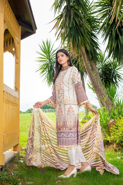 Superbe pose de côté de fille tenant sa Dupatta avec une attitude portant une robe Desi pour une séance photo de mode