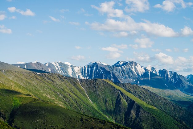 Superbe vue aérienne sur les grandes montagnes rocheuses enneigées et le grand glacier sous le ciel bleu. Magnifique paysage de hautes terres vives avec des montagnes géantes de neige. Beau paysage alpin avec des montagnes glaciaires.