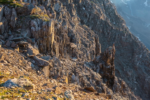 Superbe vue ensoleillée sur la montagne depuis la falaise à très haute altitude Paysage alpin pittoresque avec de beaux rochers pointus et des couloirs au soleil Beau paysage de montagne au bord de l'abîme avec des pierres pointues