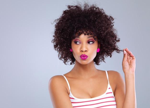 De superbes boucles naturelles Prise de vue en studio d'une belle jeune femme sur un fond gris