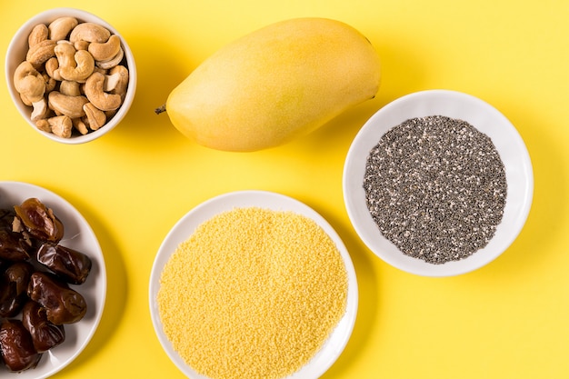 Superfoods dans des bols sur fond jaune.